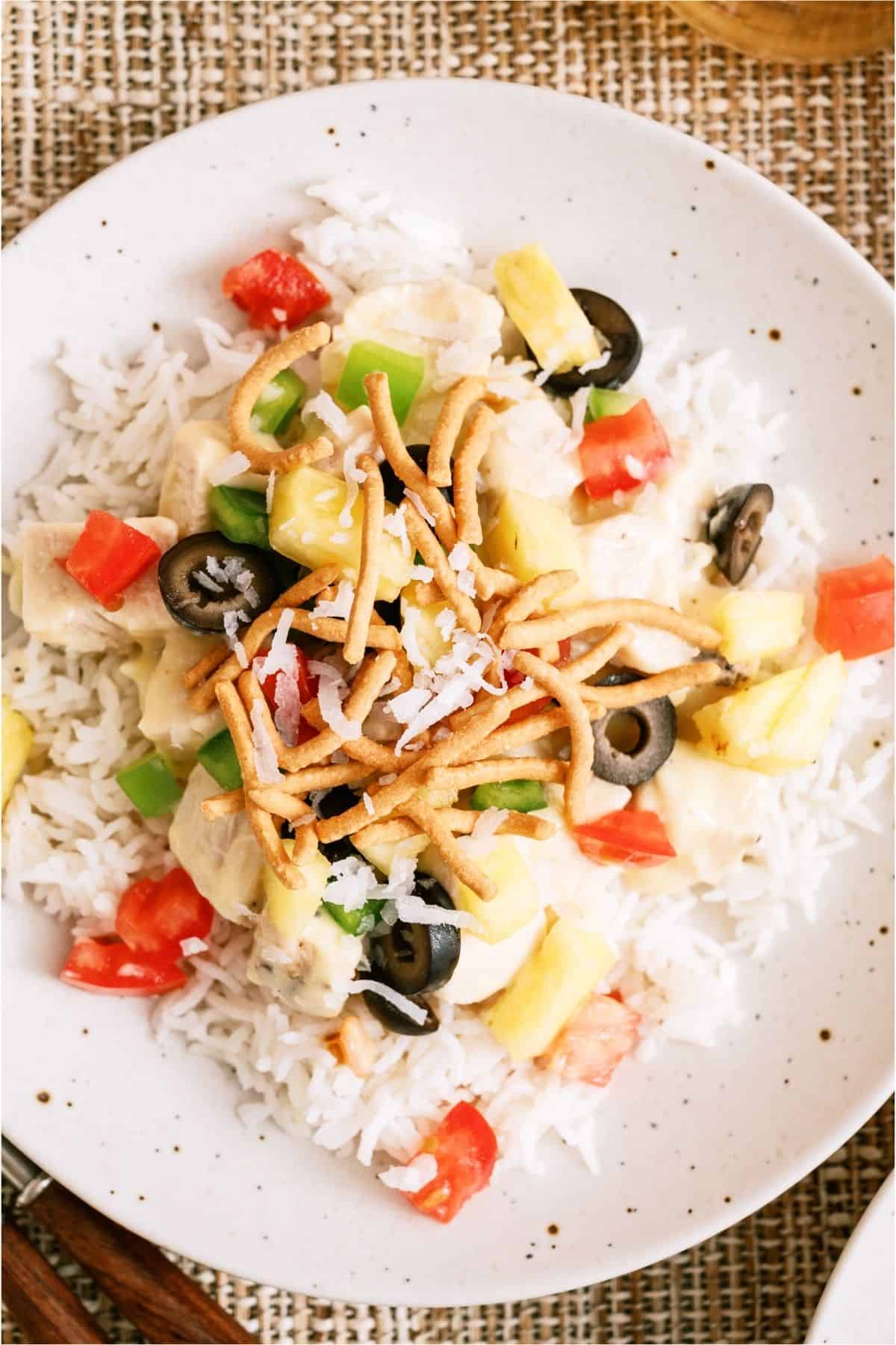 Top view of a plate with a serving of Hawaiian Haystacks with toppings.