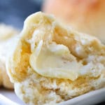 Instant Pot roll on a plate sliced in half with a pat of butter on it,