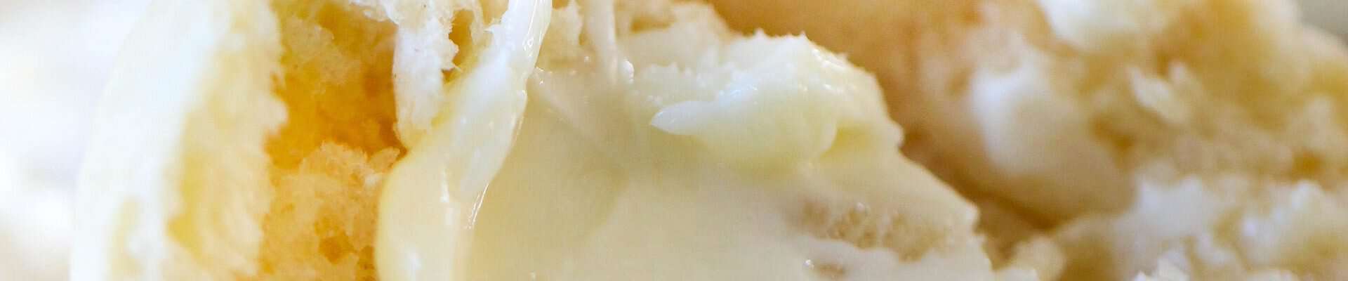 Instant Pot roll on a plate sliced in half with a pat of butter on it,