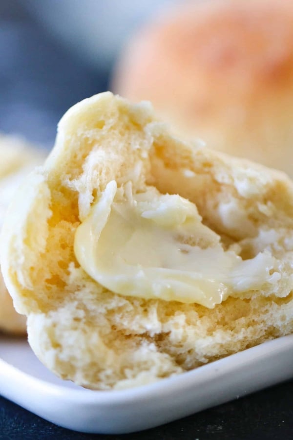 Instant Pot roll on a plate sliced in half with a pat of butter on it,