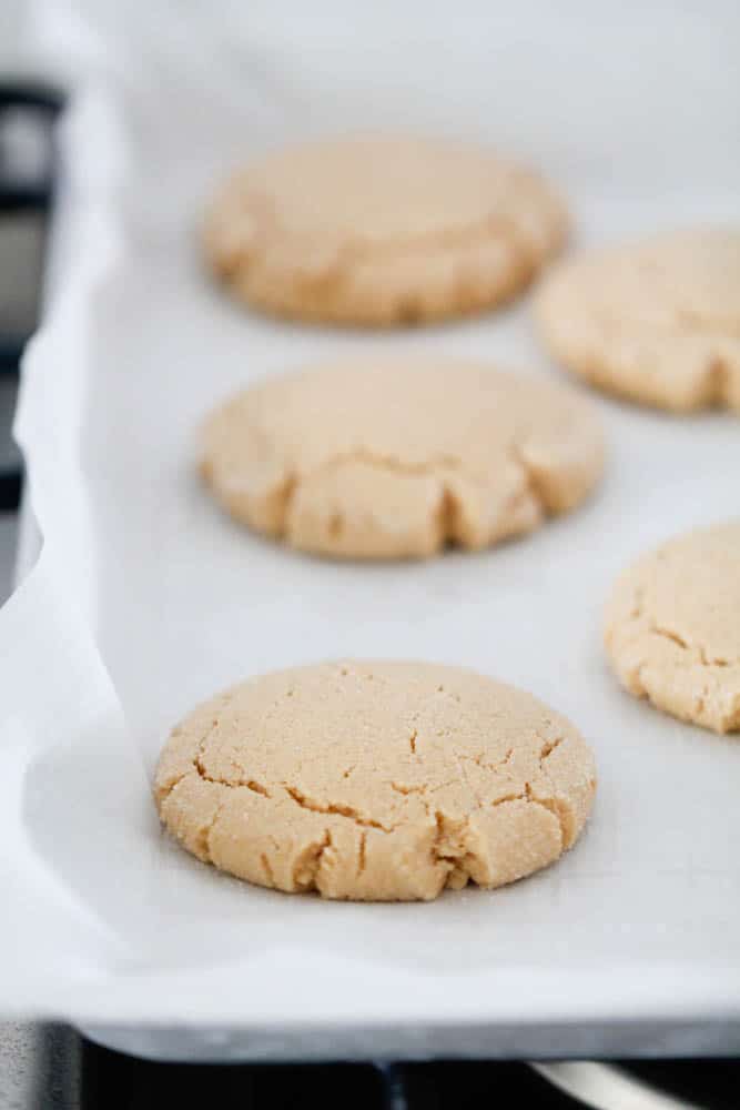 Freshly baked peanut butter cookies on a baking sheet.