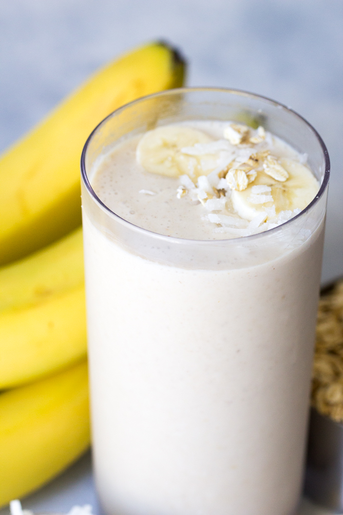 Banana Breakfast Smoothie in a glass with a banana on the side