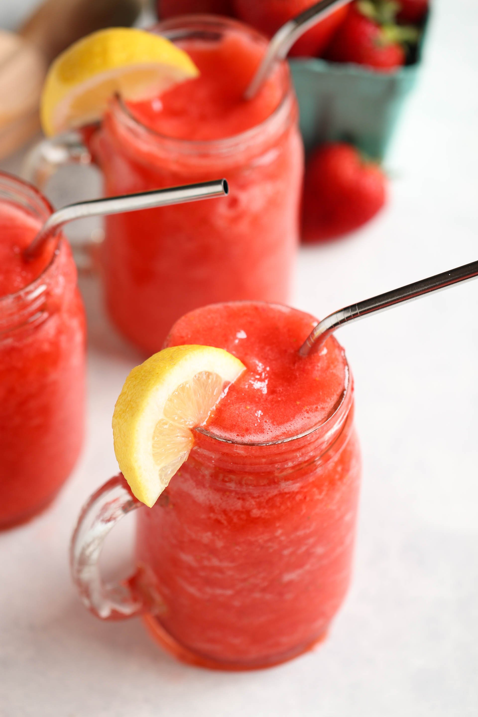 Copycat Lemonberry Slush in jars with handles and a metal straw
