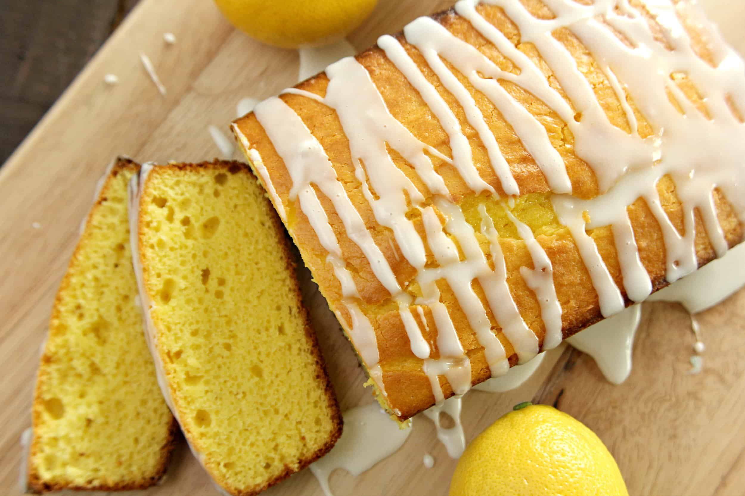 Starbucks Copycat Lemon Pound Cake on a cutting board sliced with lemons