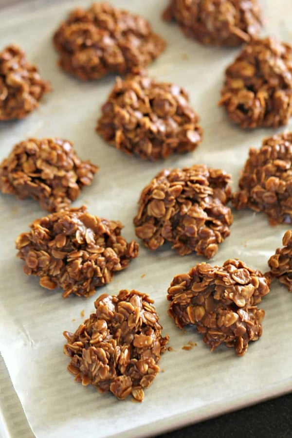A tray of healthy no-bake cookies made with oats and chocolate, set on parchment paper.