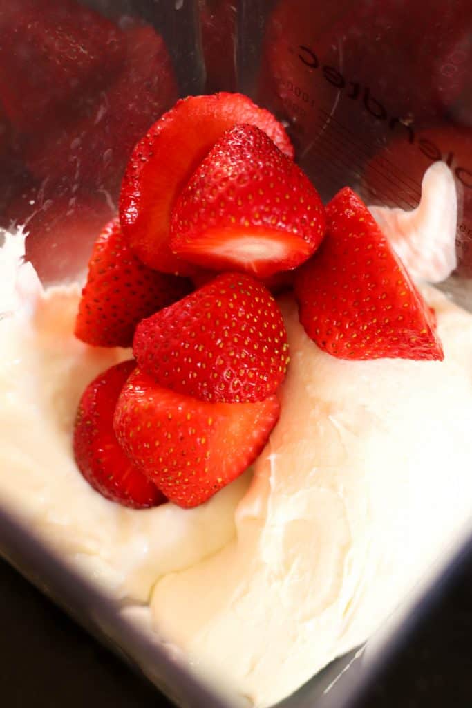 Strawberries and yogurt in a blender.