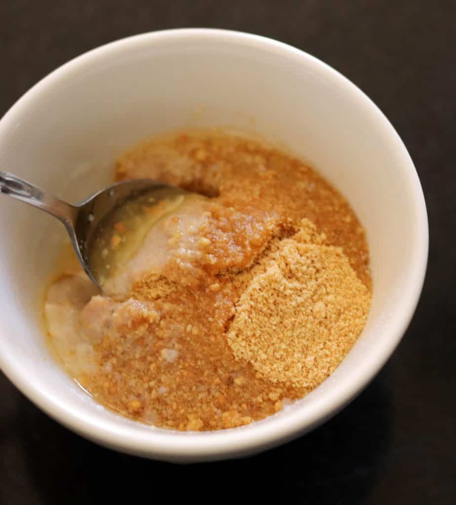 Mixing cheesecake crumb mixture in a small bowl.
