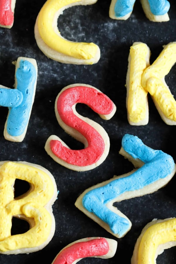 Back to school sugar cookies in the shape of letters with frosting in different colors.