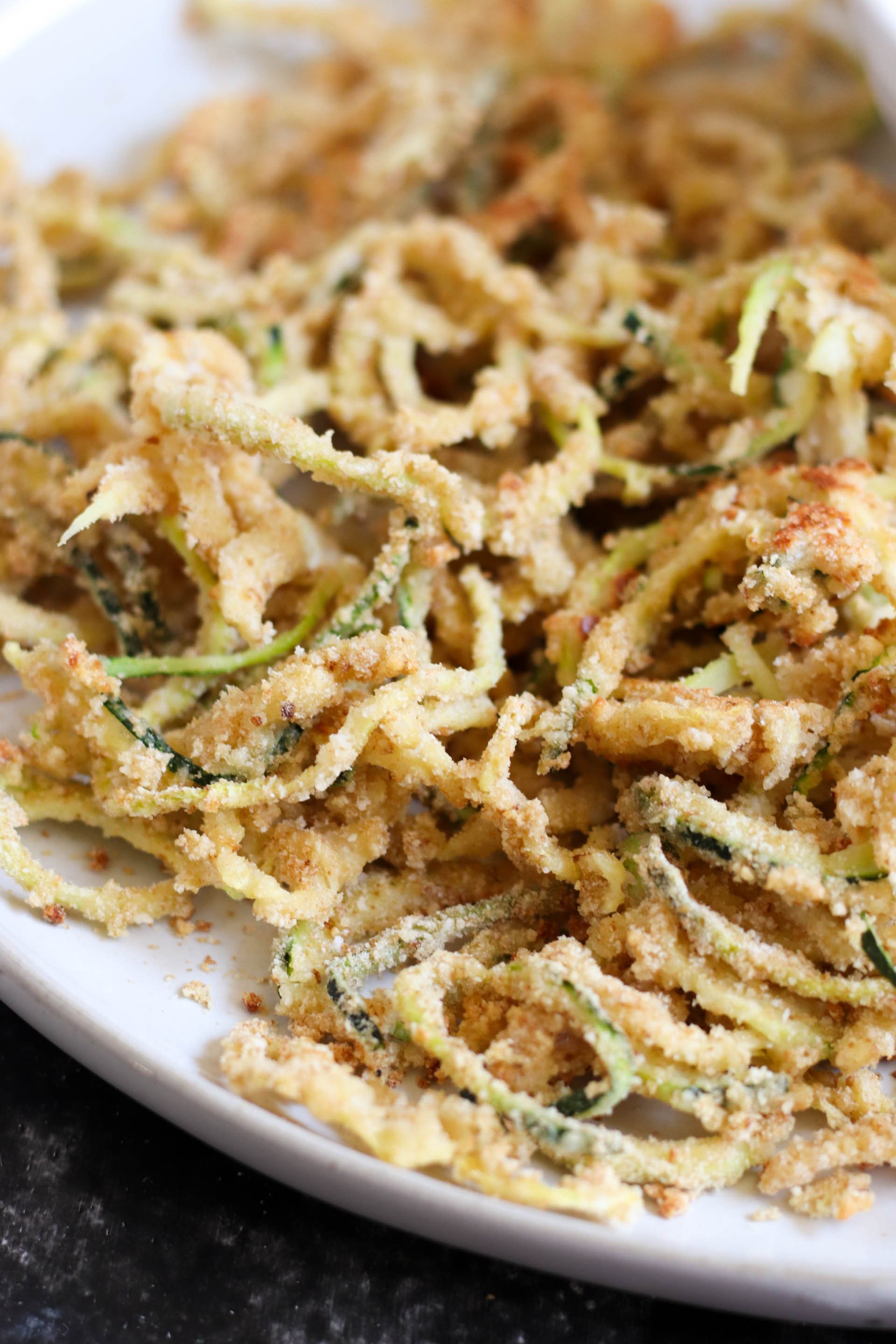 Baked Parmesan Zucchini Strings on a white plate