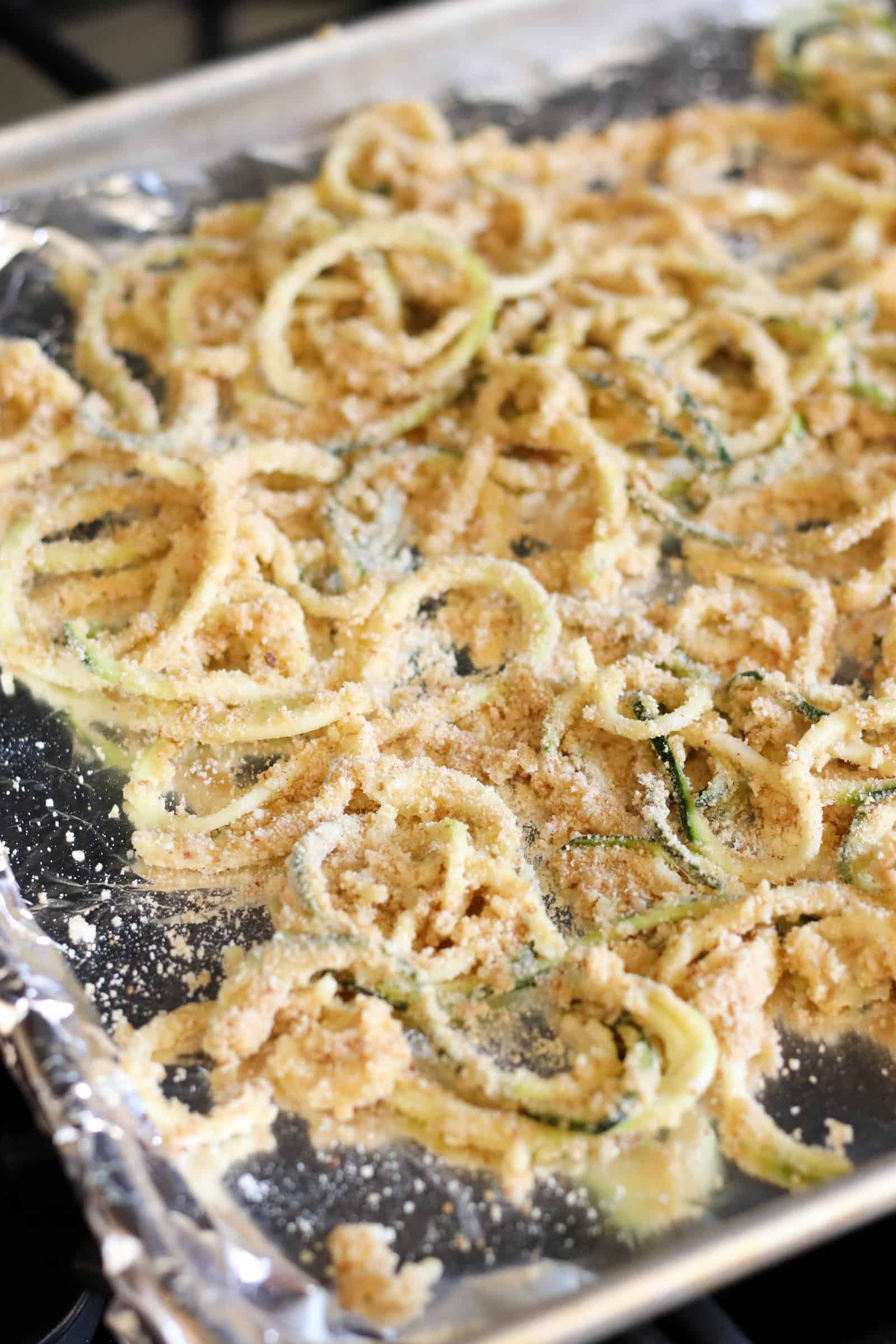 Unbaked Parmesan Zucchini Strings on baking sheet