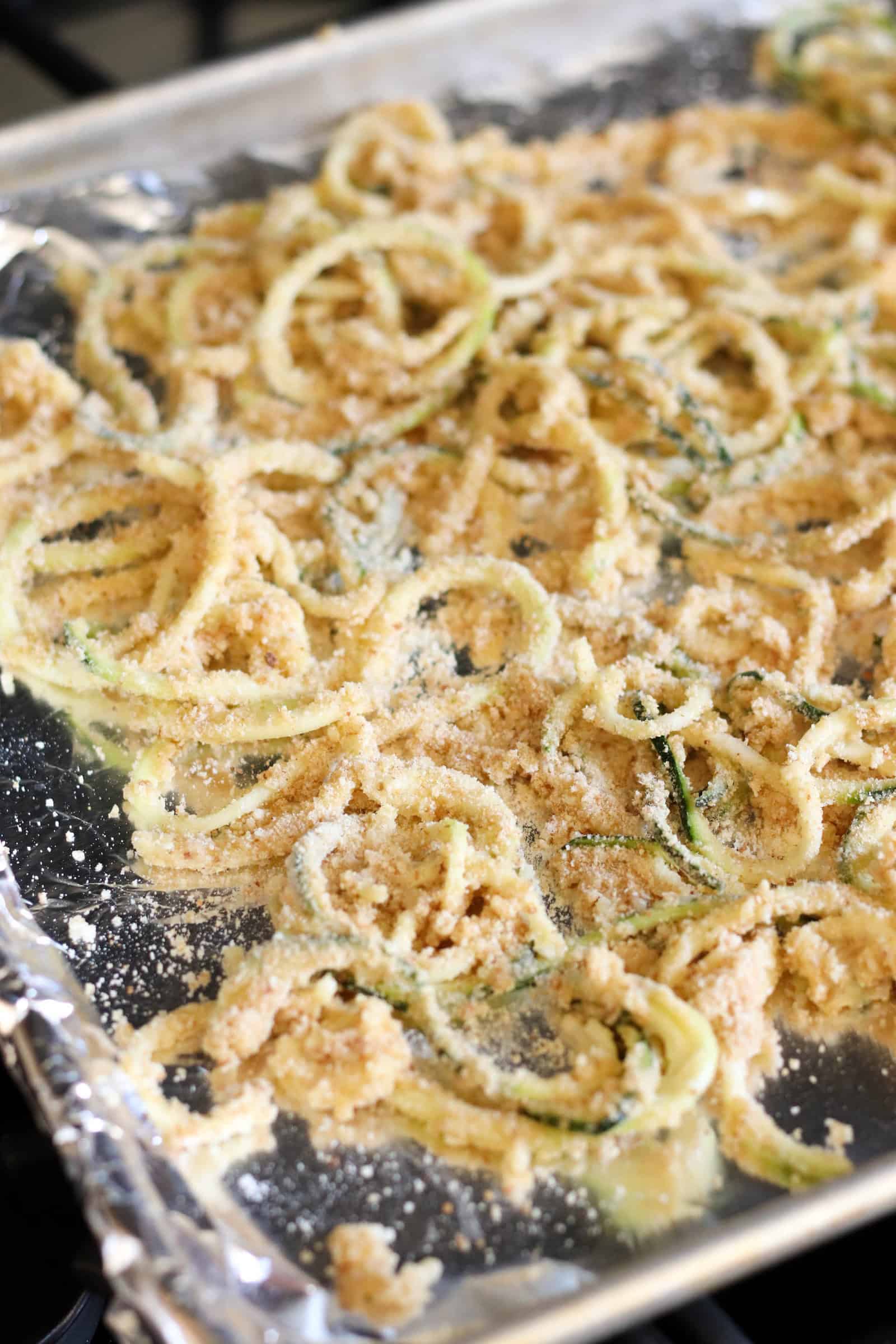 Unbaked Parmesan Zucchini Strings on baking sheet
