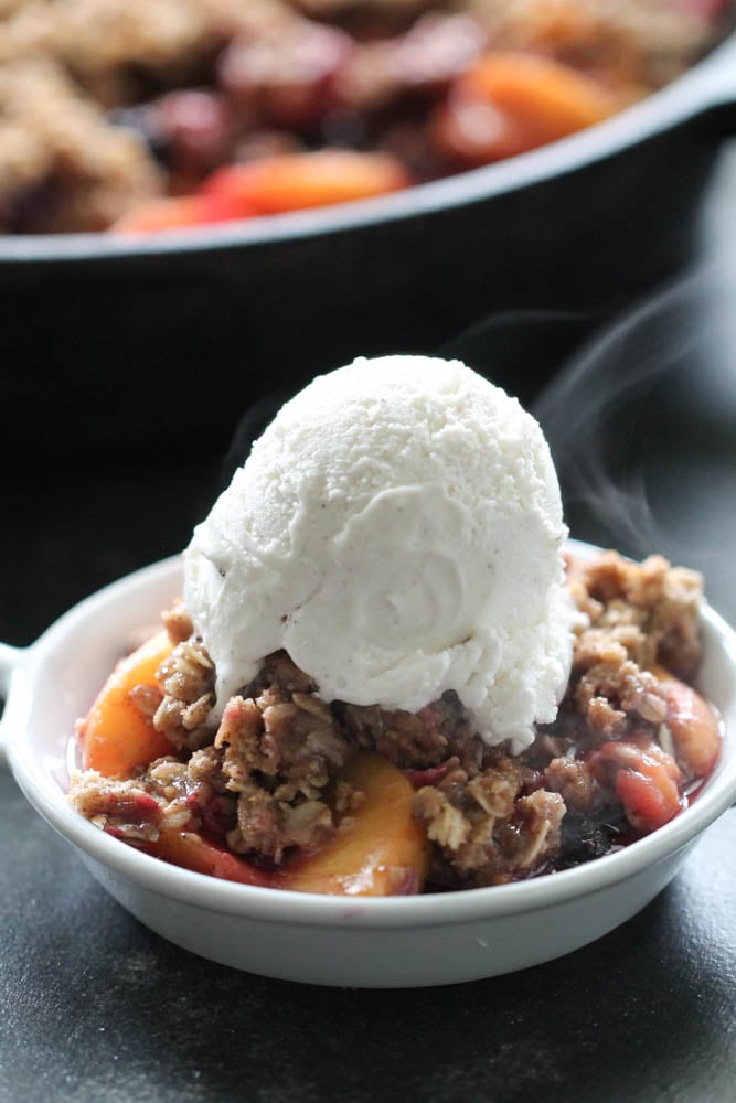 Peach and Berry Crisp in a bowl with a scoop of Ice Cream on top