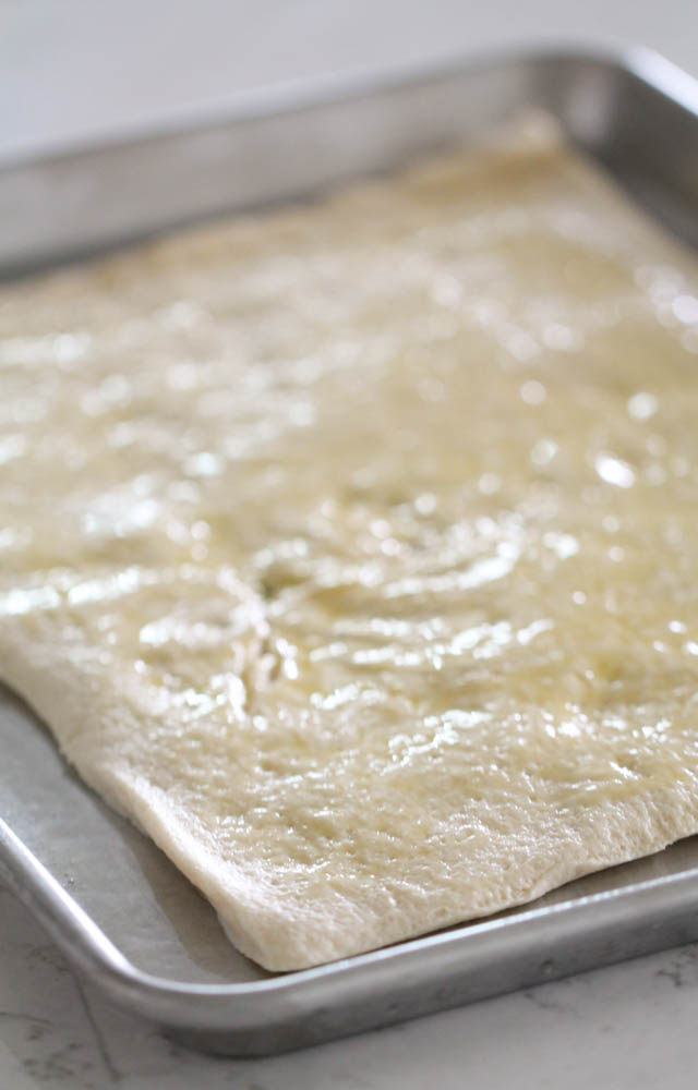 Pizza Crust dough rolled out on a baking sheet