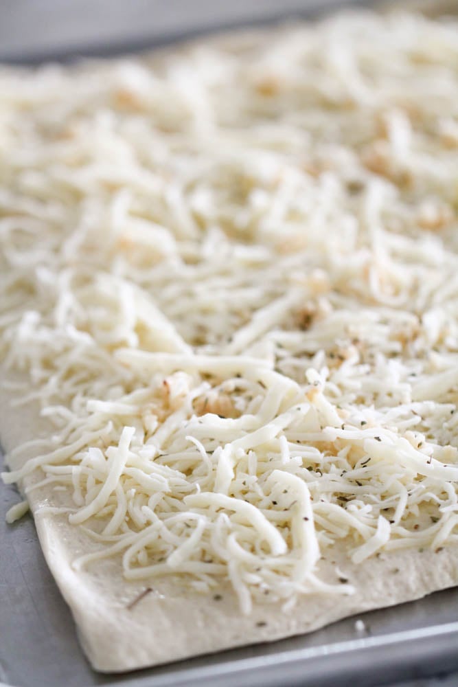 fresh shredded parmesan cheese on top of dough