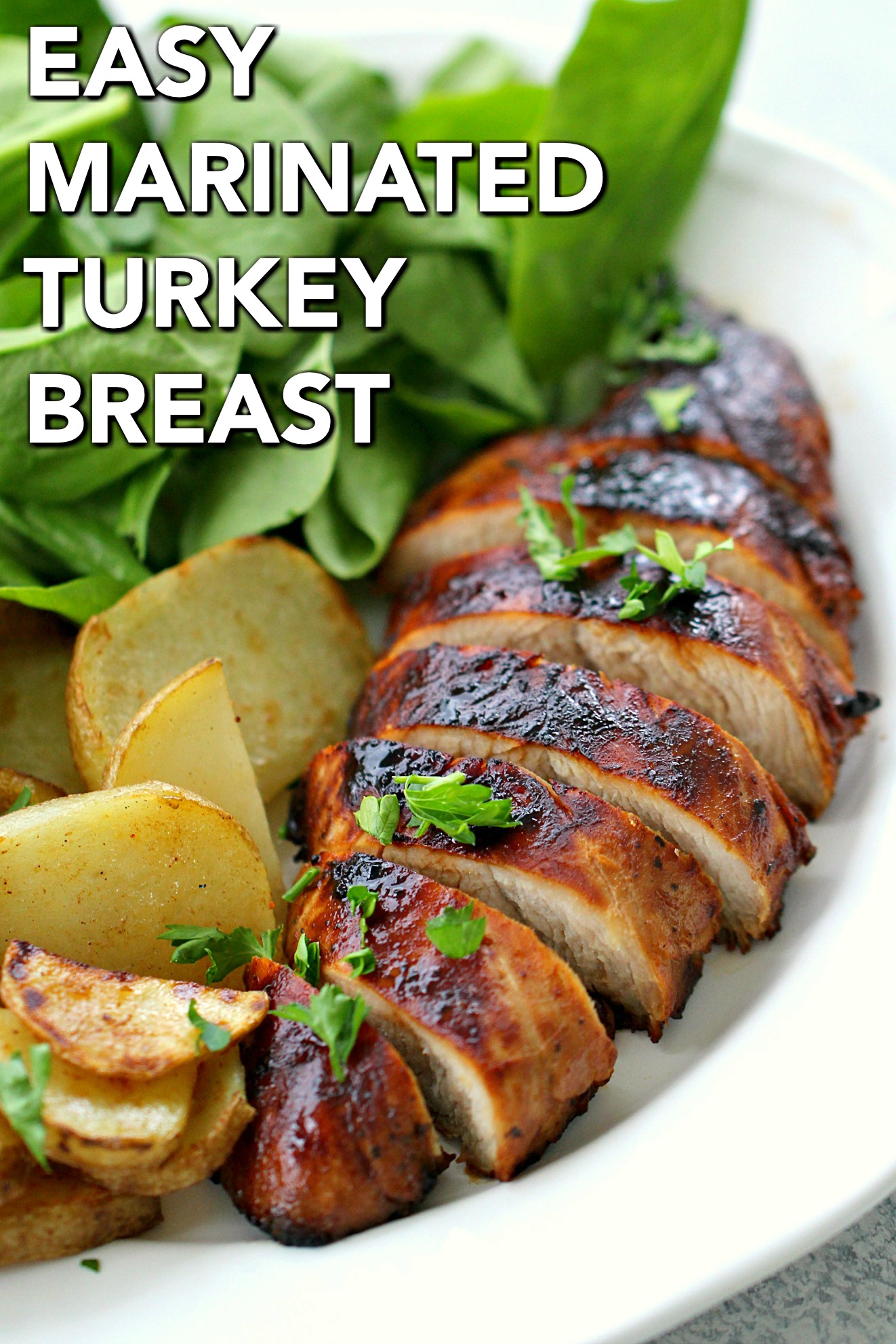 Easy Marinated Turkey Breast sliced, on a plate with potatoes and salad