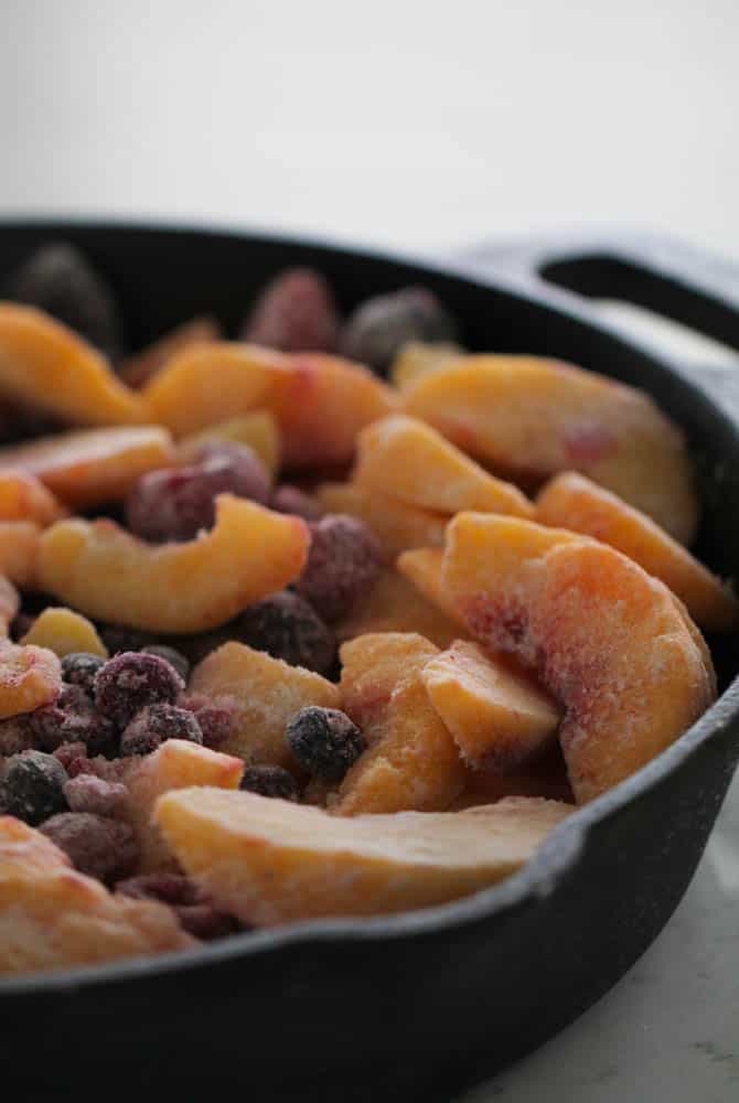 Peach and Berry Crisp in a skillet without the crisp mixture on top