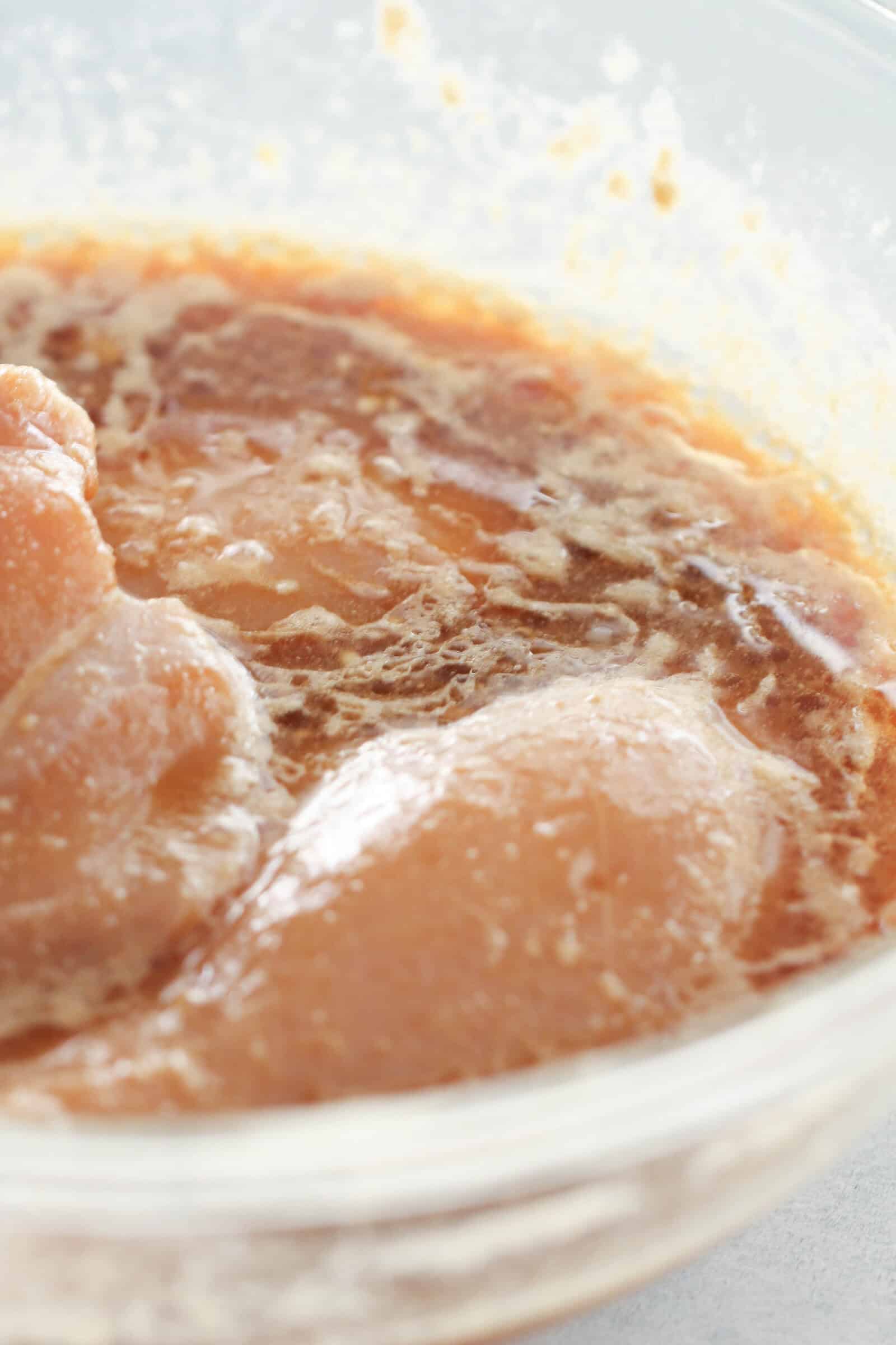 Chicken and Marinade in a glass bowl