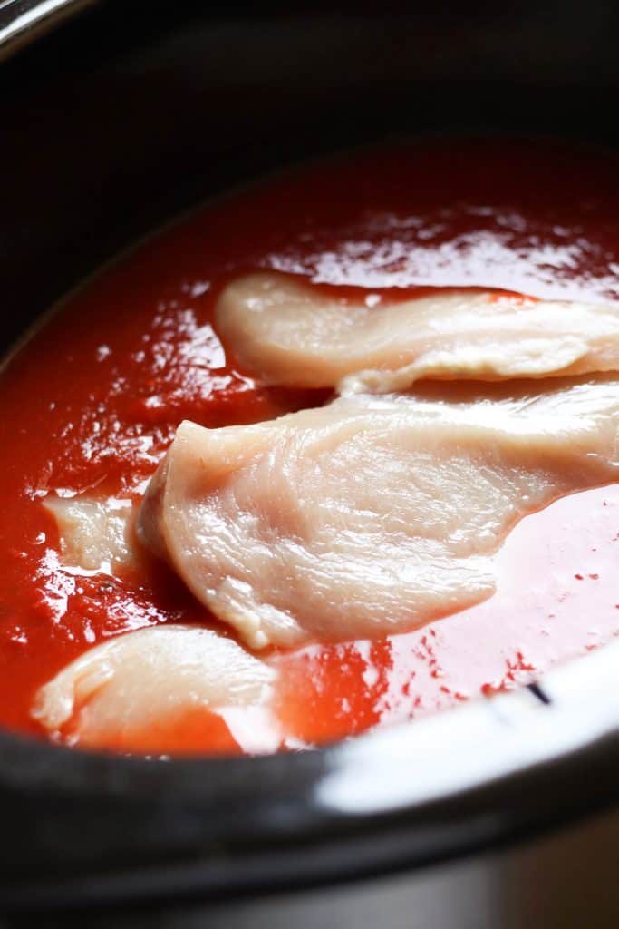 Chicken in the slow cooker with red sauce.
