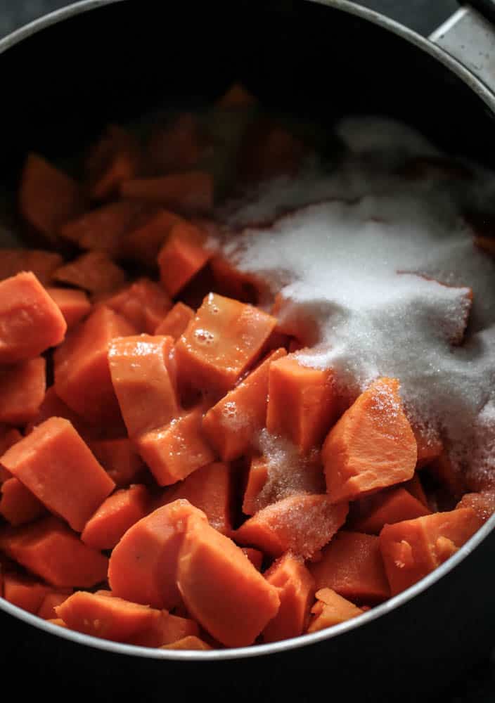 sweet potatoes diced in a pot with sugar on top