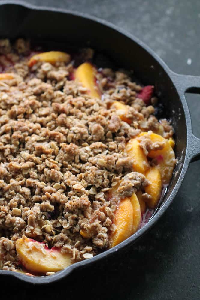 Freshly baked Peach and Berry Crisp in a skillet.