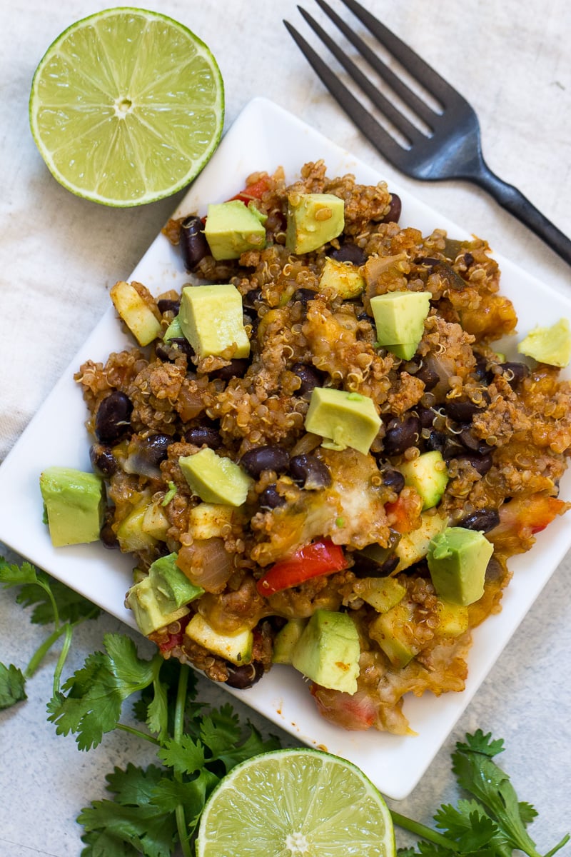 Zucchini Taco Casserole on a white plate, topped with avocado cubes