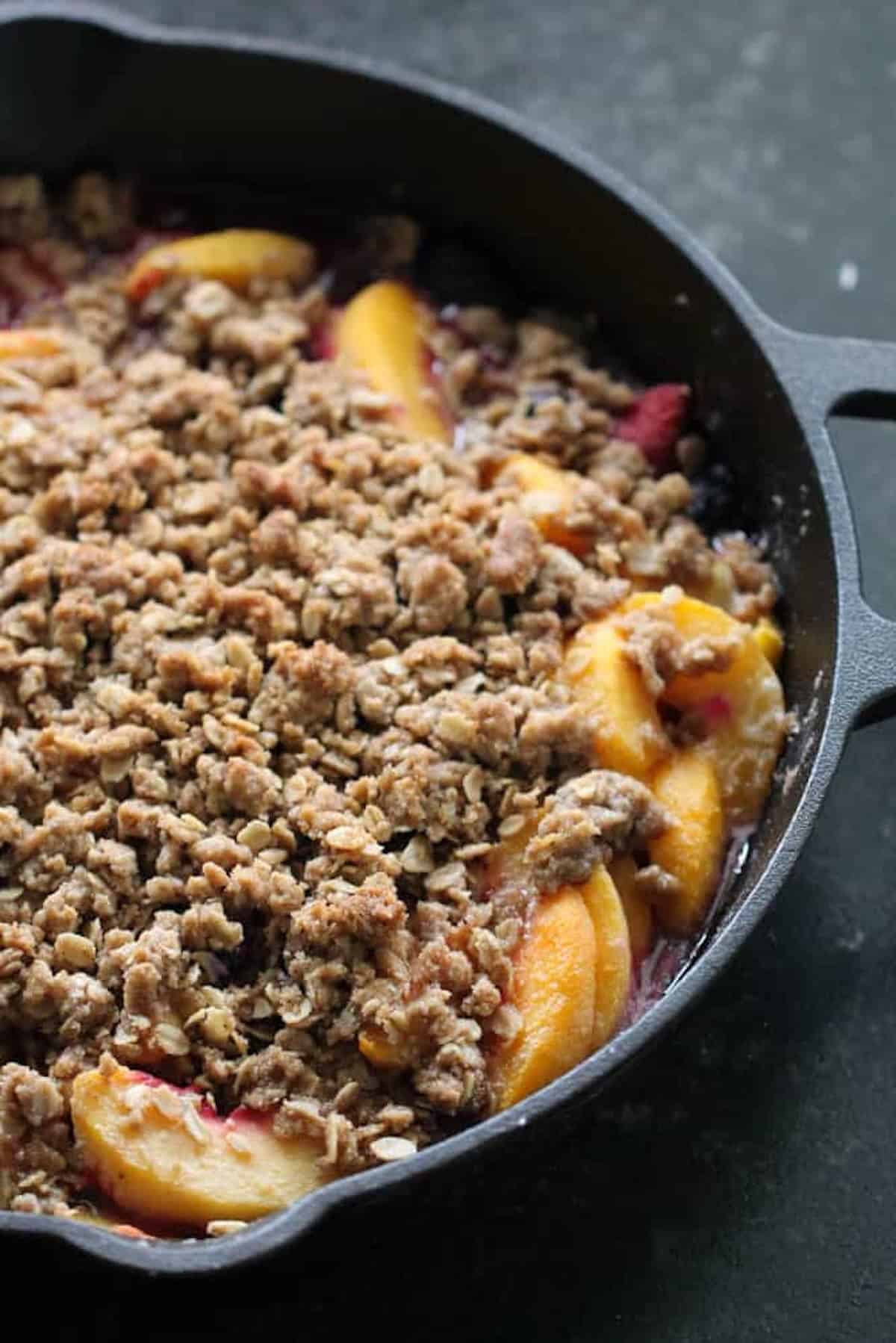Freshly baked Peach and Berry Crisp in a skillet.