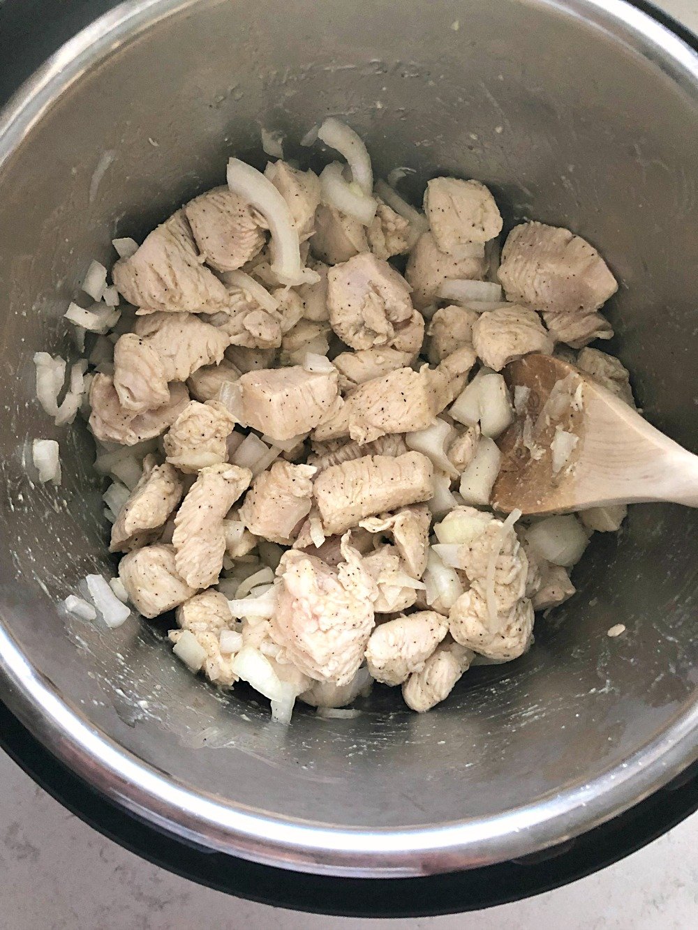 chicken and onions being sauteed in an instant pot