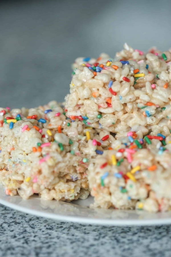 A plate with 3 Creamy Funfetti Cake Batter Rice Krispie Treats.
