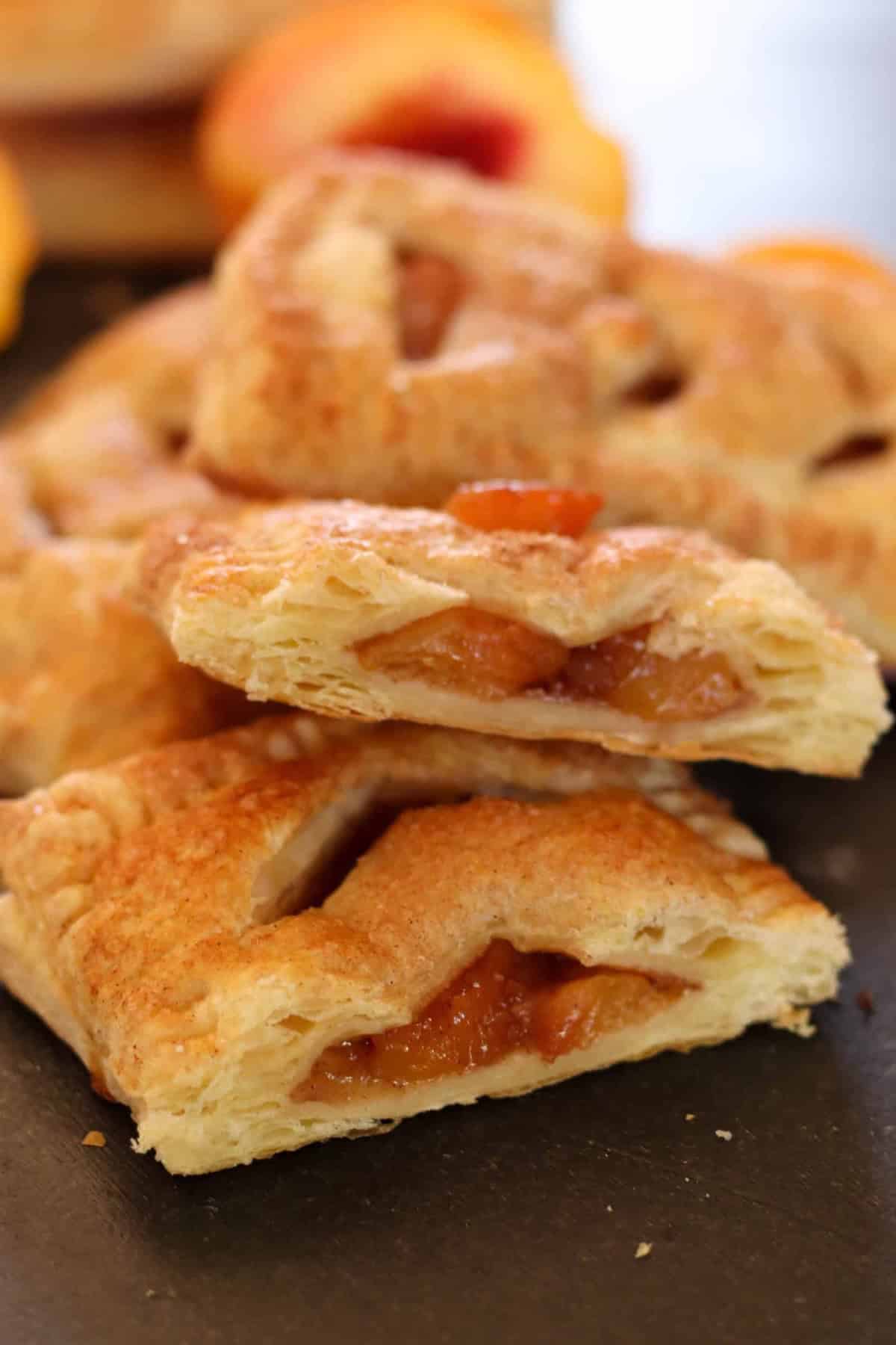 2 Baked Peach Hand Pies broken in half stacked on top of each other.