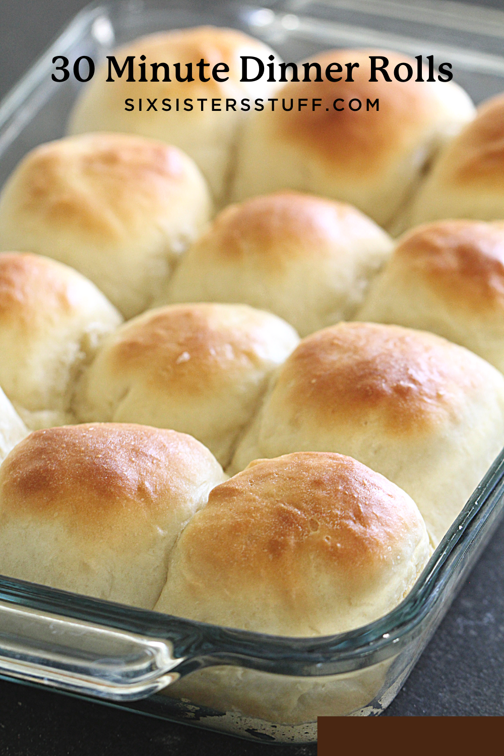 Homemade rolls in a 9x13 inch baking pan with butter on top