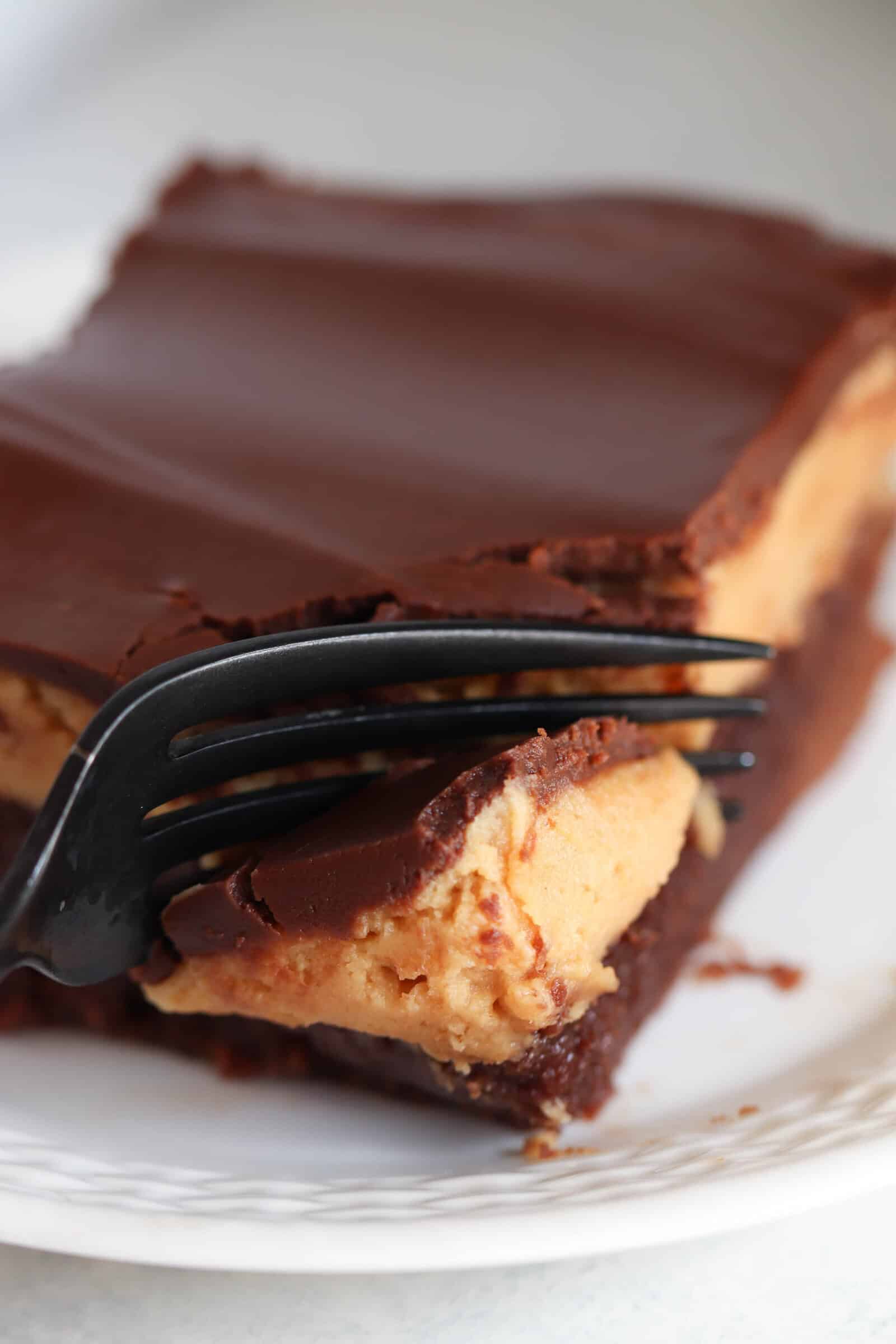 A fork is holding a piece of chocolate peanut butter brownies.