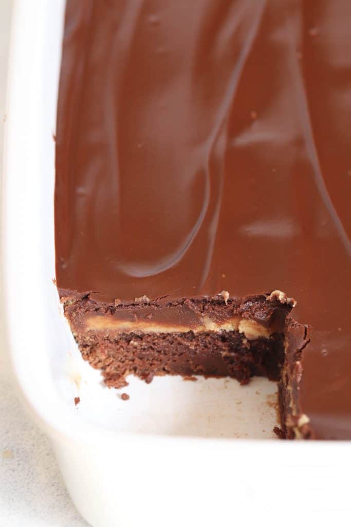 A pan of Buckeye Brownies with a corner piece missing to show the inside.