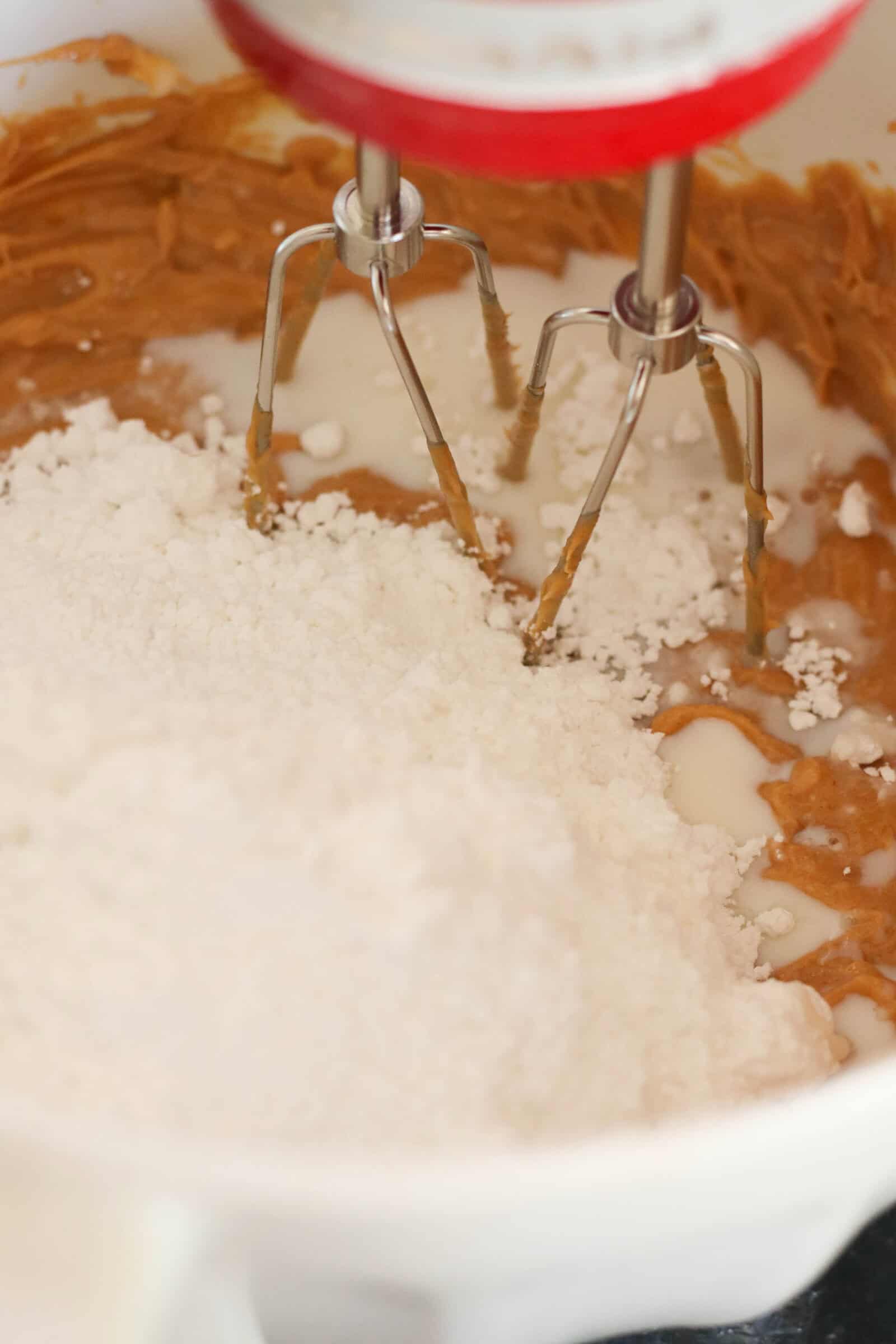 Peanut butter layer ingredients in mixing bowl with electric beaters