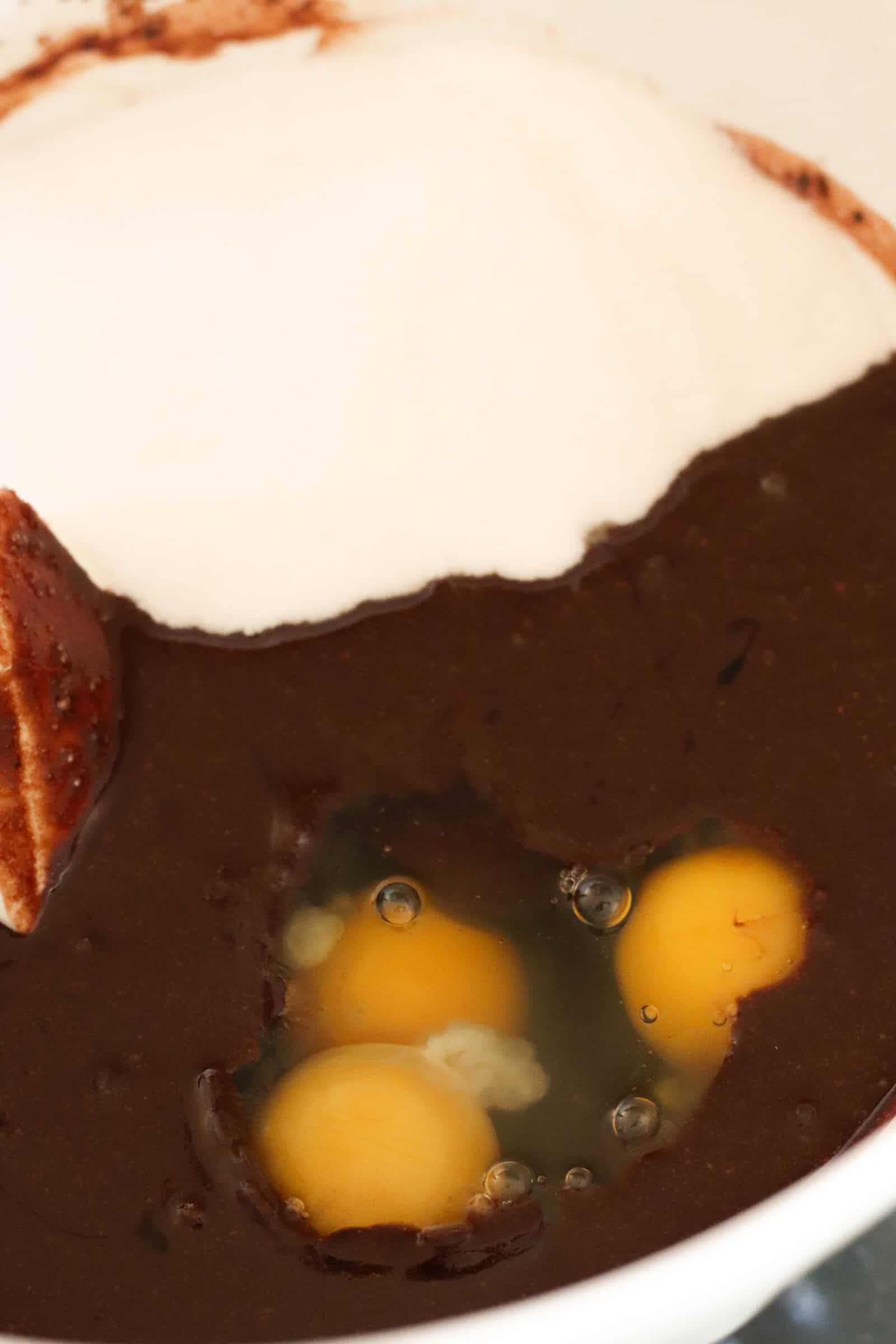 Ingredients for brownie layer in a white mixing bowl