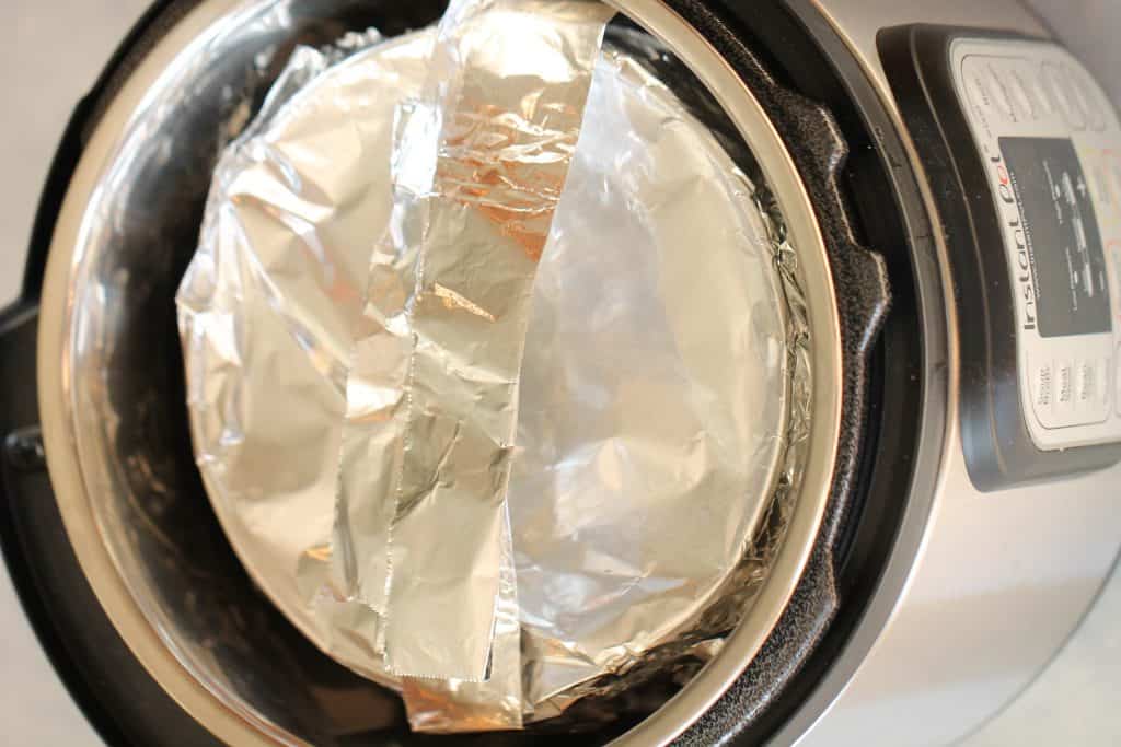Instant pot with a springform pan covered in foil.