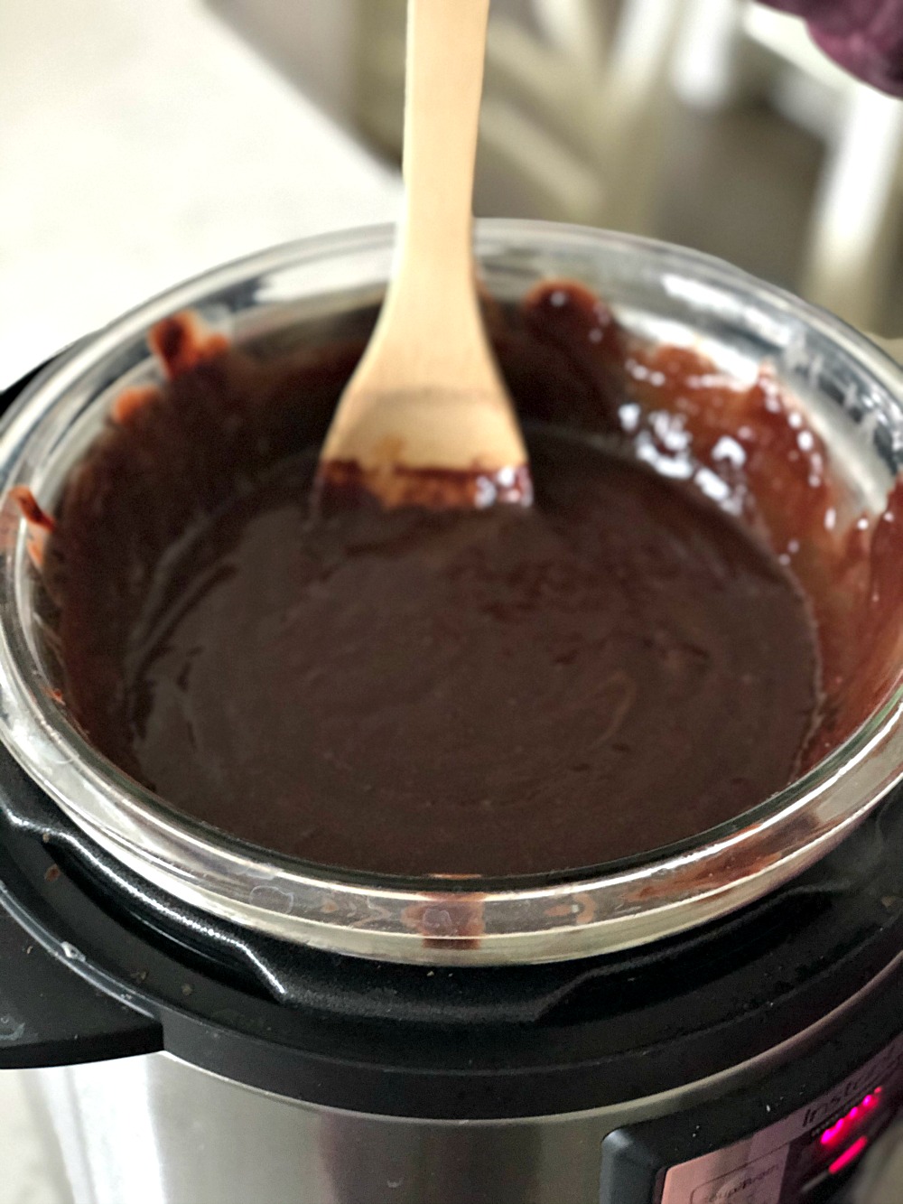 Wooden spoon stirring chocolate mixture un glass bowl