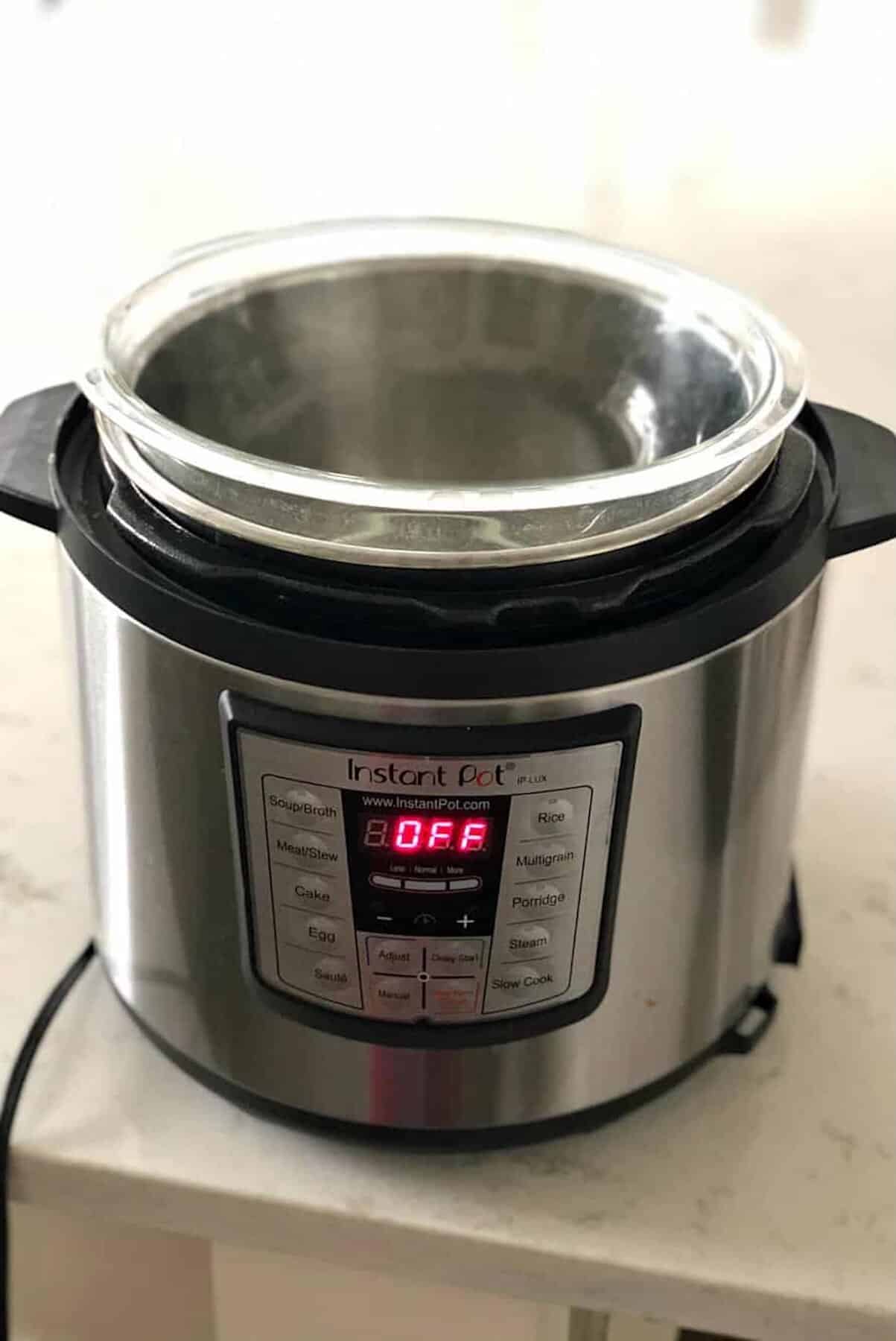 A glass bowl is placed inside an Instant Pot electric pressure cooker on a kitchen counter, with the display showing "OFF.