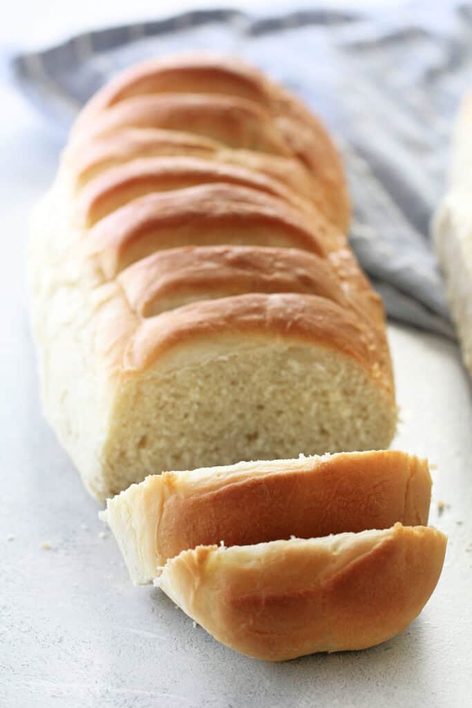 loaf of homemade french bread on the counter with two slices cut off the end