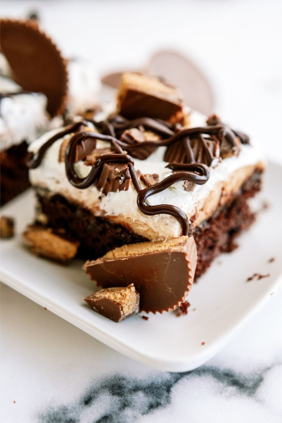 A slice of Reese’s Peanut Butter Poke Cake on a plate

