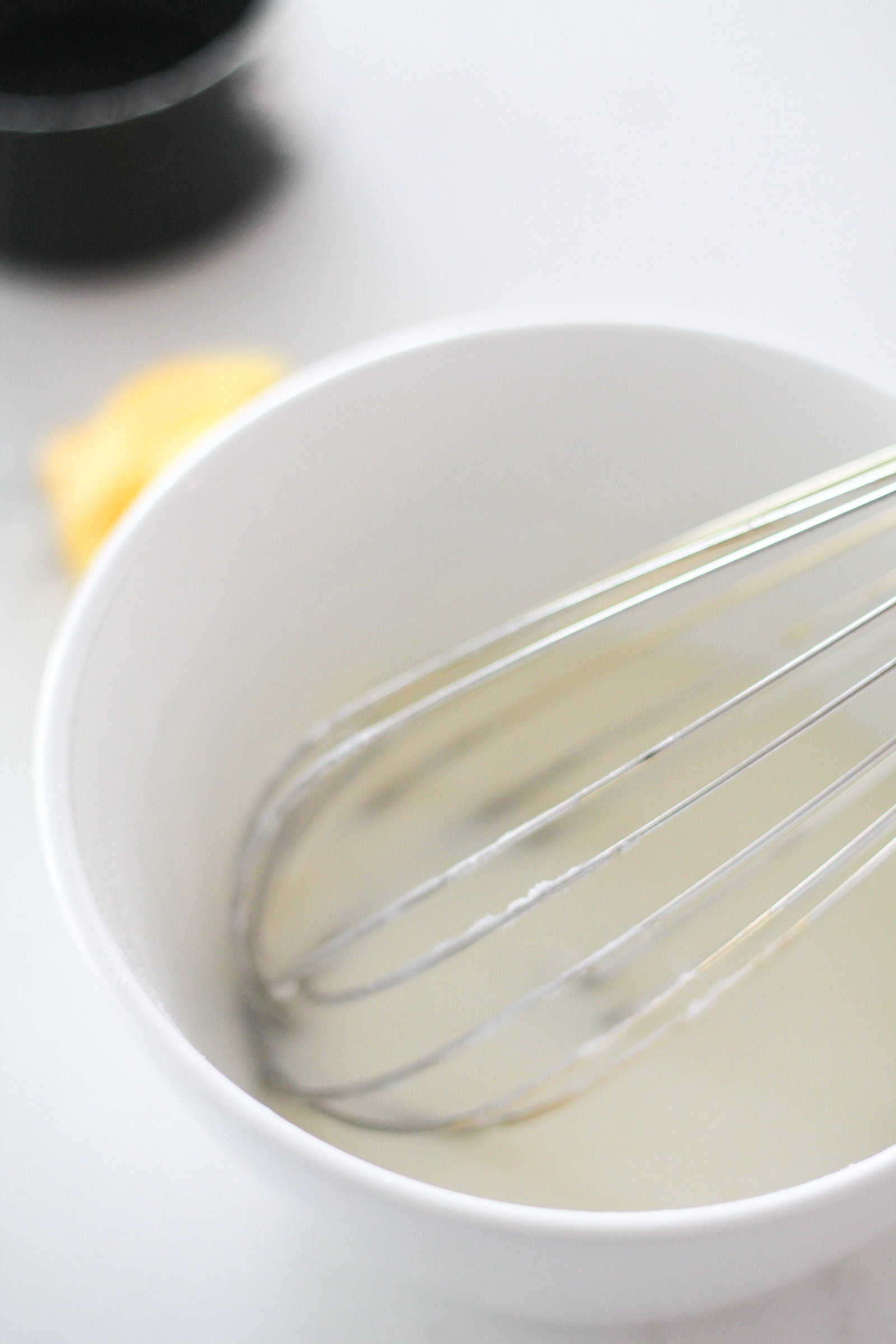 Powdered sugar mixture in a bowl with a whisk