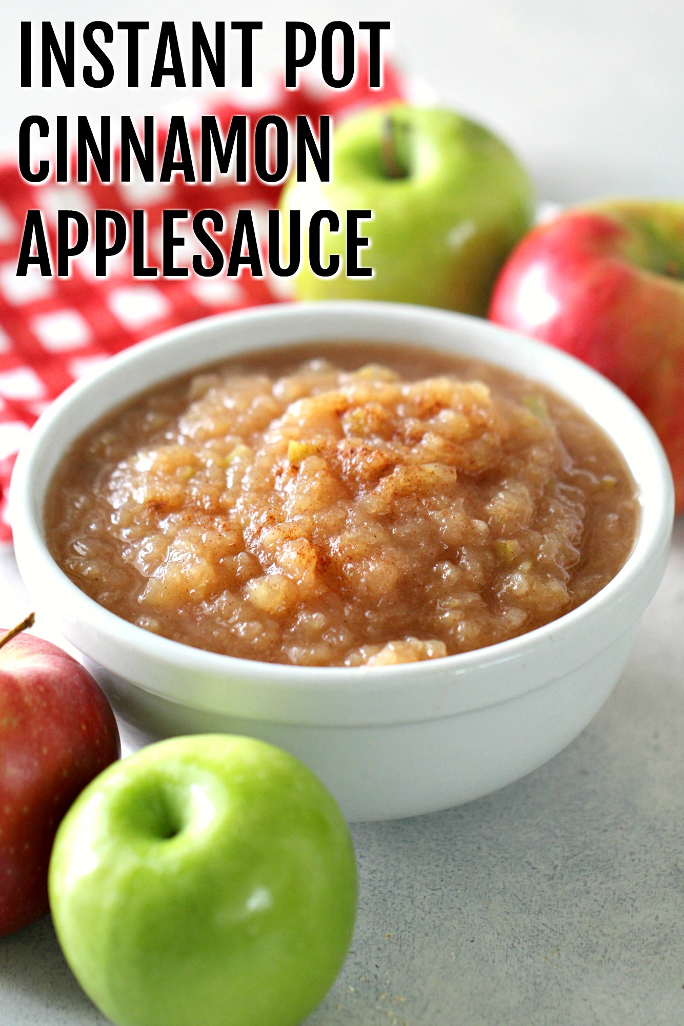 Instant Pot Cinnamon Applesauce in a bowl surrounded by apples