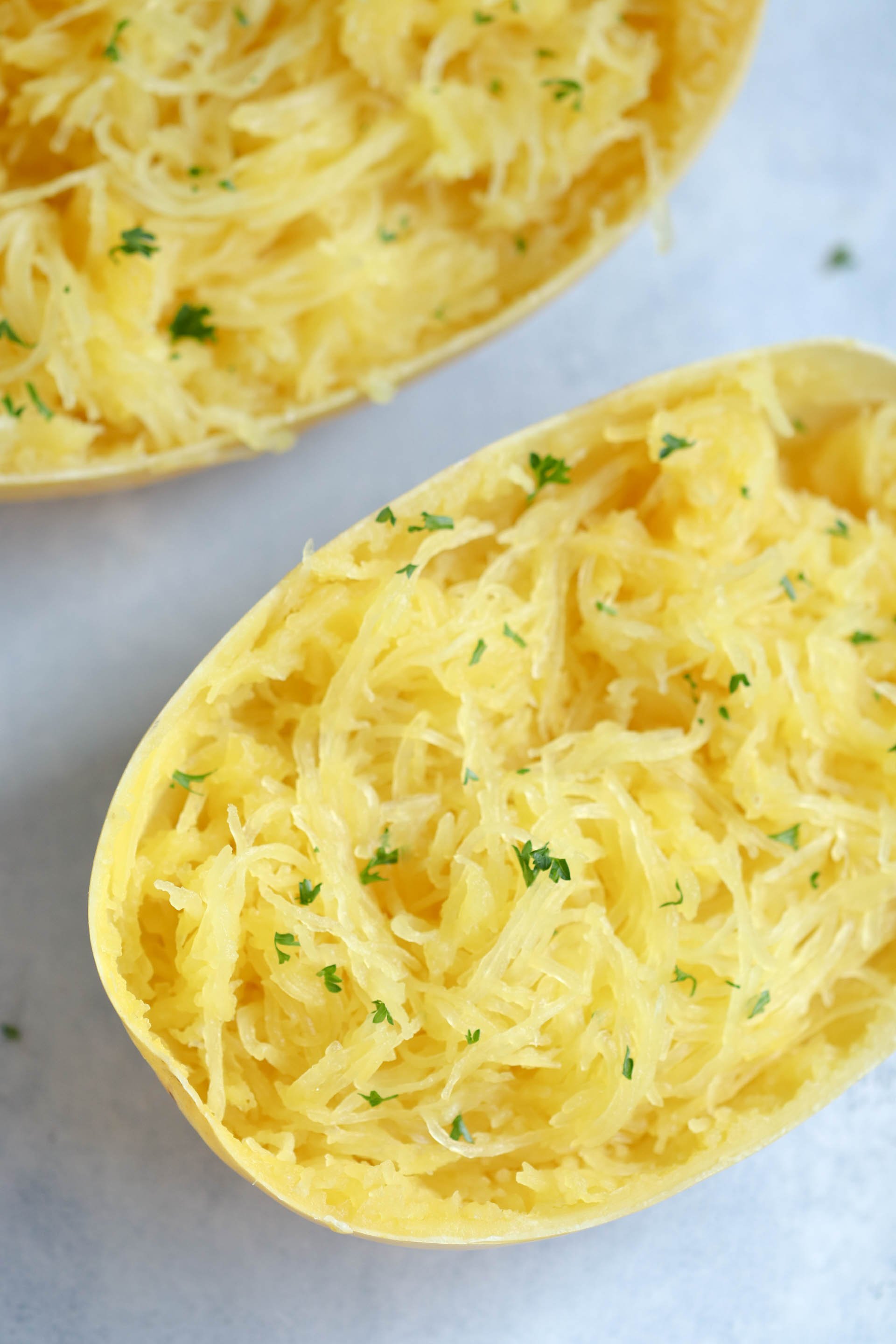2 Spaghetti Squash halves filled with cooked and shredded spaghetti squash