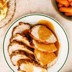 A plate of Slow Cooker Company Pork Roast sliced with gravy on top.
