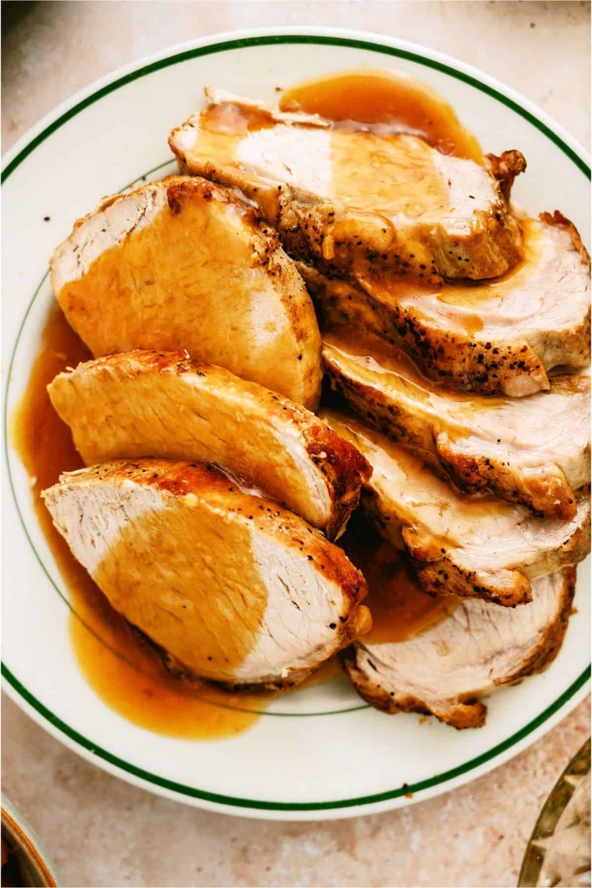 Top view of a plate of Slow Cooker Company Pork Roast slices and topped with gravy.