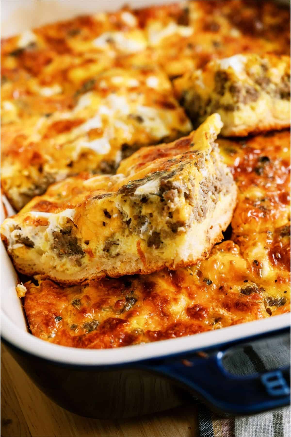One square of Sausage Breakfast Casserole being lifted out of casserole dish.
