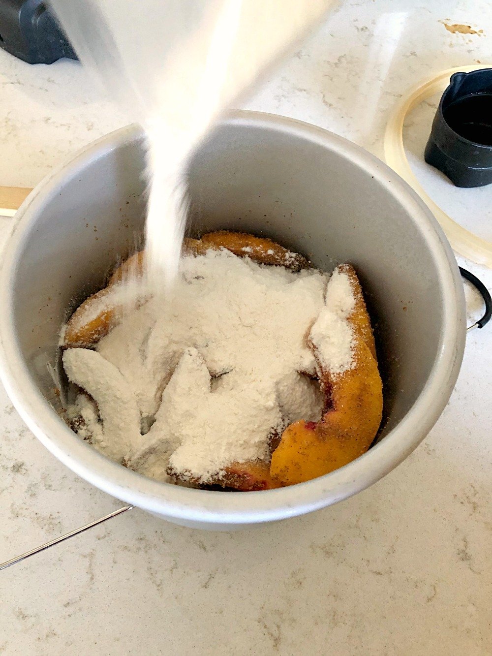 Pouring yellow cake mix over peaches in instant pot