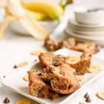 Chunky Monkey Brownies cut into squares on a white serving plate.
