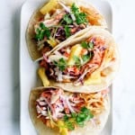 plated hawaiian bbq chicken tacos ready to serve with toppings of pineapple, cilantro, and onions