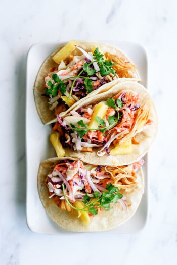 plated hawaiian bbq chicken tacos ready to serve with toppings of pineapple, cilantro, and onions