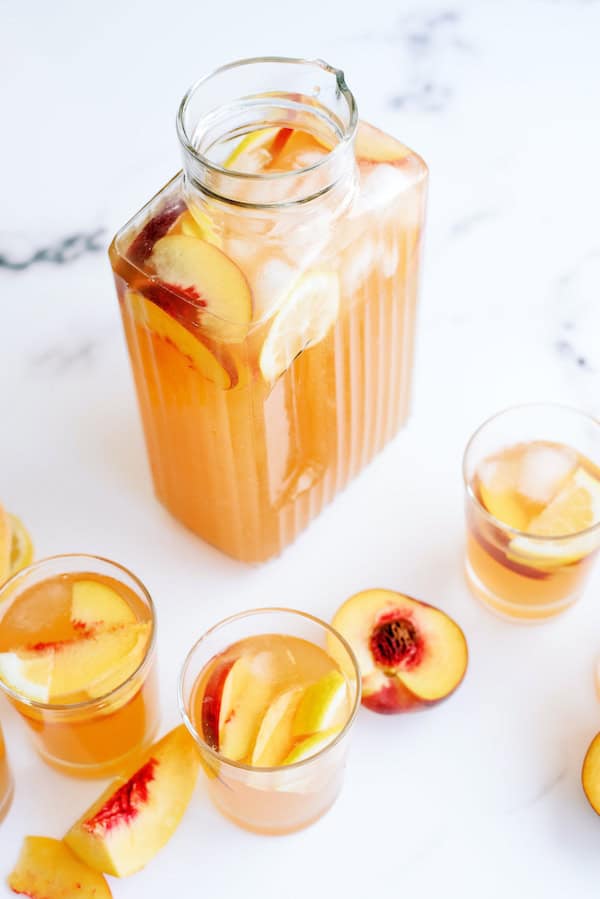 Pitcher and glasses filled with Sparkling Peach Punch